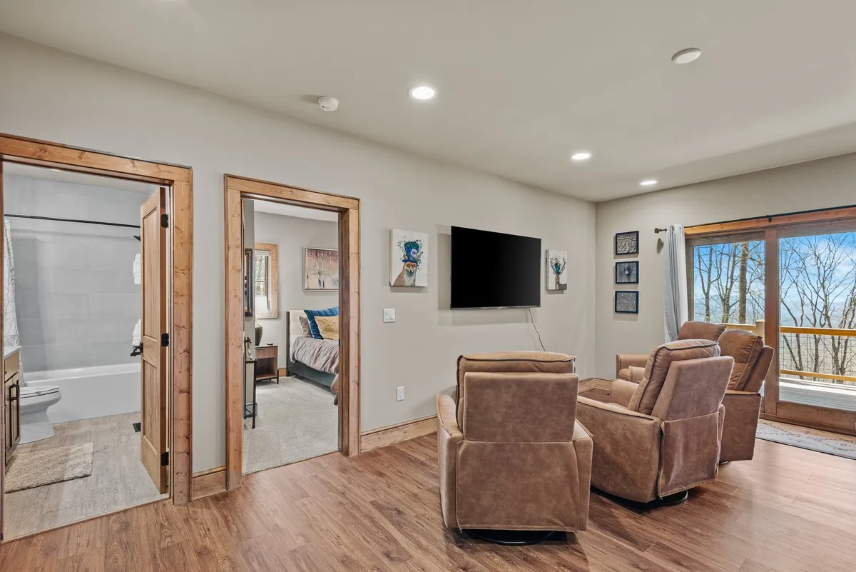 This inviting lounge area features plush recliners, a wall-mounted TV, large windows, and cheerful artwork, creating a bright, comfortable space for watching movies, playing games, or enjoying time with friends and family.