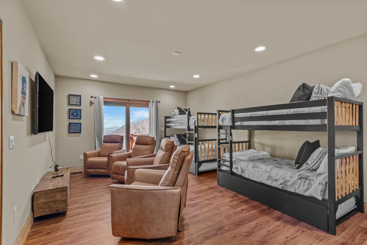 A playful lower-level space with bunk beds, recliners, and a large window with views outside. The setting feels relaxed and ideal for sleepovers or movie marathons, aligning with the section’s emphasis on both comfort and fun for kids and families.